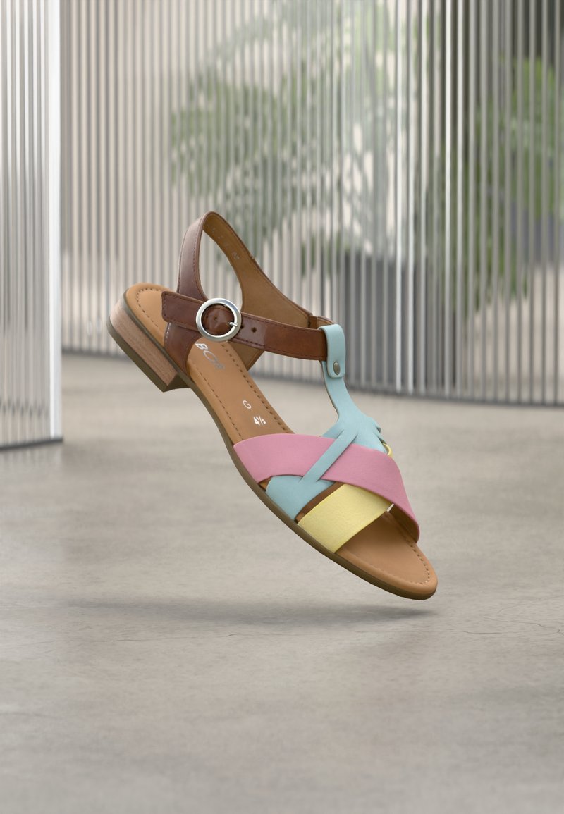 Χρωματιστό σανδάλι με καφέ δερμάτινο λουράκι, ανοιχτό μπλε, ροζ και κίτρινα σταυρωτά λουράκια, με στρογγυλή μεταλλική αγκράφα και χαμηλό τακούνι.