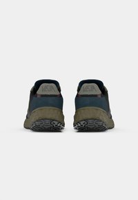 Sneakers de culoare albastru închis și verde măsliniu, cu o talpă din cauciuc texturat, având o guler căptușit și un logo pe călcâi.