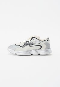 Silver and cream sneaker with a textured upper, black accents, and a rounded, chunky sole featuring distinctively shaped pods.