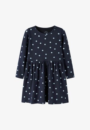 Granatowa sukienka z długim rękawem w jasnoniebieskie kropki, z okrągłym dekoltem, marszczonym pasem i rozkloszowanym dołem. Wykonana z miękkiej bawełny.