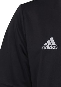 Svart sportströja med rundhals, korta ärmar och en strukturerad tygkvalitet. Broderad vit Adidas-logotyp på bröstet.