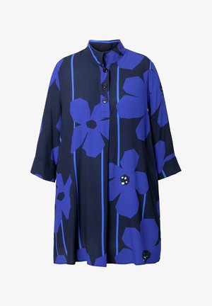 Blå blomster tunika med høj krave, der har store marine- og blå blomster, knaplukning foran og trekvartærmer. Blødt stof med let glans.