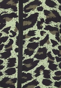 Tessuto con stampa animale nei toni nero e verde oliva con un aspetto texturizzato, caratterizzato da una cerniera centrale nera. Lo sfondo è di colore verde chiaro.
