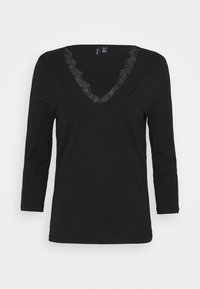 T-shirt nero a maniche lunghe con scollatura a V, caratterizzata da dettagli in pizzo nero lungo il collo. Tessuto morbido con una superficie liscia.