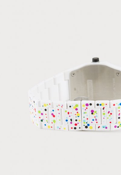 Montre blanche avec un bracelet rectangulaire de style maillon orné de points multicolores en rouge, rose, vert, jaune et noir. Dos en métal.