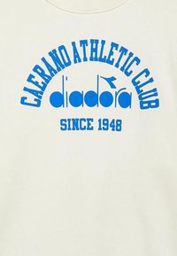 Felpa color crema con testo blu "CAERANO ATHLETIC CLUB" curvato sopra "diadora" e "SINCE 1948" in basso.