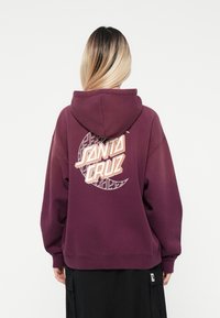 Felpa bordeaux con cappuccio regolabile, caratterizzata da una grande grafica sul retro con il testo "Santa Cruz" e un design geometrico.