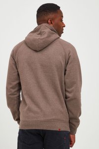 Sudadera con capucha marrón de acabado texturizado, que presenta un bolsillo tipo canguro y puños de canalé. La vista trasera muestra la capucha y los detalles de las costuras.
