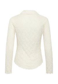 Čipkovaná blúzka v off-white farbe, s dlhými rukávmi, golierom a textúrovaným kvetinovým vzorom, so zúbkovaným lemovaním.