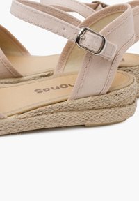 Sandali espadrille beige con cinturini incrociati in tela, fibbia in metallo e suola in juta intrecciata. Fodera interna liscia e plantare piatto.