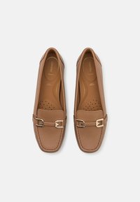 Brune lærloafers med teksturert finish, med gullhardware og perforerte innersåler for pusteevne. Elegant og strømlinjeformet design.