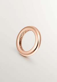 Anillo de oro rosa con un exterior liso y brillante y un centro hueco, que presenta una superficie interior con patrones y pequeños recortes.