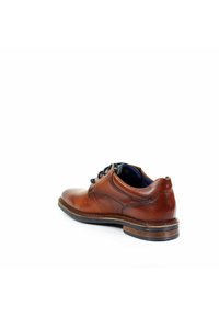 Braune Leder-Dressschuhe mit runder Zehenform, Schnürdesign und einer kontrastierenden dunklen Sohle. Glatte Textur mit subtilen Nähdetails.