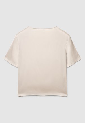 Blusa beige in raso a maniche corte con scollo rotondo e vestibilità rilassata, caratterizzata da una texture liscia e cuciture pulite. Nessun ornamento visibile.