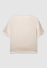 Blusa beige in raso a maniche corte con scollo rotondo e vestibilità rilassata, caratterizzata da una texture liscia e cuciture pulite. Nessun ornamento visibile.