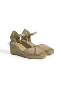 Escarpins compensés en suède beige avec une semelle en jute tressé. Design à lanières croisées avec une sangle à la cheville à l'arrière. Accent métallique décoratif le long de la couture.