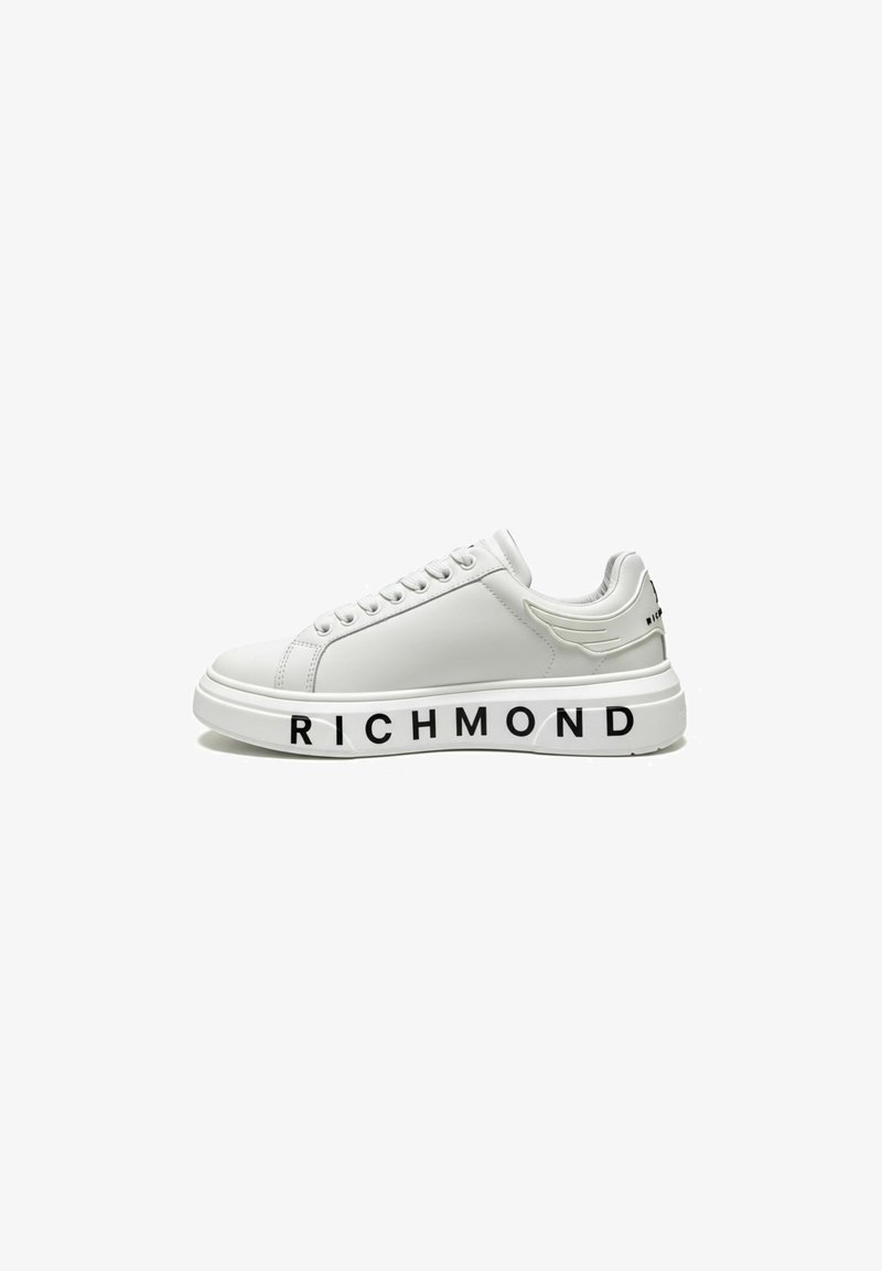 Witte lage sneaker met dikke zool, veters aan de voorkant en "RICHMOND" in zwarte letters op de buitenzool gedrukt.