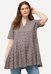 Tunique à manches courtes au motif floral violet et crème, avec un décolleté en V et une forme évasée avec un ourlet évasé pour un ajustement décontracté.