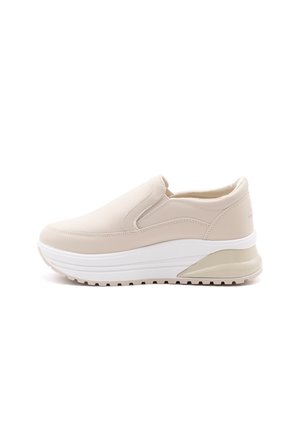 Beige slip-on sneakers with a smooth leather upper, thick white sole, and light tan accents. Rounded toe and cushioned interior design.