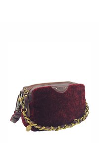 Sac à bandoulière en fausse fourrure bordeaux avec des accents en cuir, chaîne dorée, fermeture éclair et logo sur le devant. Forme rectangulaire.