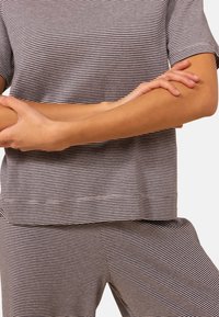 Gestreept loungewear set in zwart en wit, met een top met korte mouwen en bijpassende onderkant. Zacht materiaal met een ontspannen pasvorm.