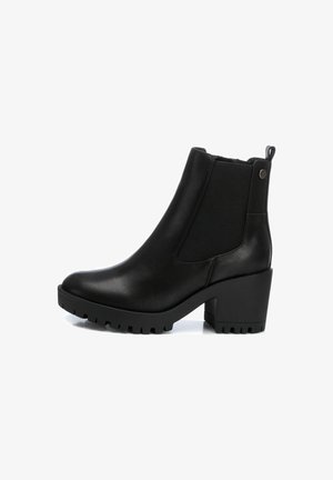 Botines negros con material de cuero suave, paneles laterales elásticos, un tacón cuadrado grueso y una suela de goma texturizada.