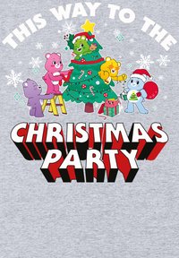 Bare v barevném kresleném stylu zdobící vánoční stromeček, text "TAMHLE JE VÁNOČNÍ PÁRTY" tučným červeným a bílým písmem na šedém pozadí.