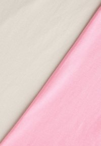 Φωτεινά μπεζ και απαλά ροζ υφασμάτινα κομμάτια τοποθετημένα διαγώνια, παρουσιάζοντας ομαλή υφή και διακριτικά ραβδώσεις.