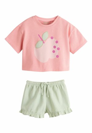 Ružové krátke tričko s krátkym rukávom, s grafikou svetloružového ovocia a zelených listov, v kombinácii so svetlozelenými šortkami so sťahovacou šnúrkou a volánikovým lemom.