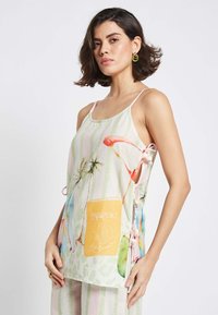 Kerge linakanga tank top pastellilistes triipudes. Omab troopilisi graafikaid, kollast "Passport" taskut ja ribavööd külgedel.