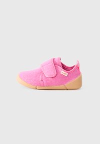 Pink fabric shoe with a textured surface, a velcro strap, and a tan rubber sole, featuring a small red tag on the side.