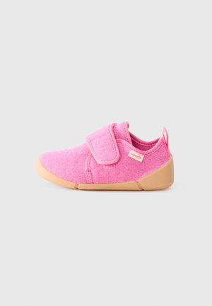 Pink fabric shoe with a textured surface, a velcro strap, and a tan rubber sole, featuring a small red tag on the side.