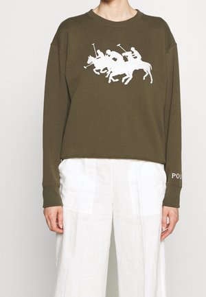 Sweat-shirt court à manches longues vert olive avec graphisme blanc de joueurs de polo à cheval et pantalon blanc à jambes larges.