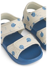 Ανοιχτόχρωμα μπλε σανδάλια με λεία, υφασμάτινη εσωτερική επένδυση και εξωτερική επιφάνεια με μοτίβο μπλε ψαριών και φυσαλίδων, εξοπλισμένα με ρυθμιζόμενους ιμάντες.