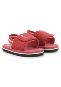 Κόκκινα σανδάλια με λουρί slide, με υφασμάτινη επένδυση με υφή, ρυθμιζόμενο λουράκι με βέλκρο και μαύρη λαστιχένια σόλα με λευκές διακοσμητικές γραμμές. Ελαφρύς σχεδιασμός.