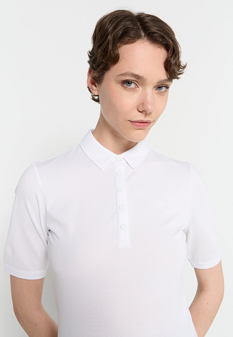 Weißes Poloshirt mit kurzen Ärmeln und Kragen, ausgestattet mit einer Knopfleiste und einem kleinen Logo auf der Brust. Glatte Textur.