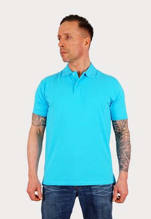 Turkos polo skjorte lavet af bomuld, med klassisk krave, korte ærmer og et diskret logo på brystet. Bæres med blå jeans.