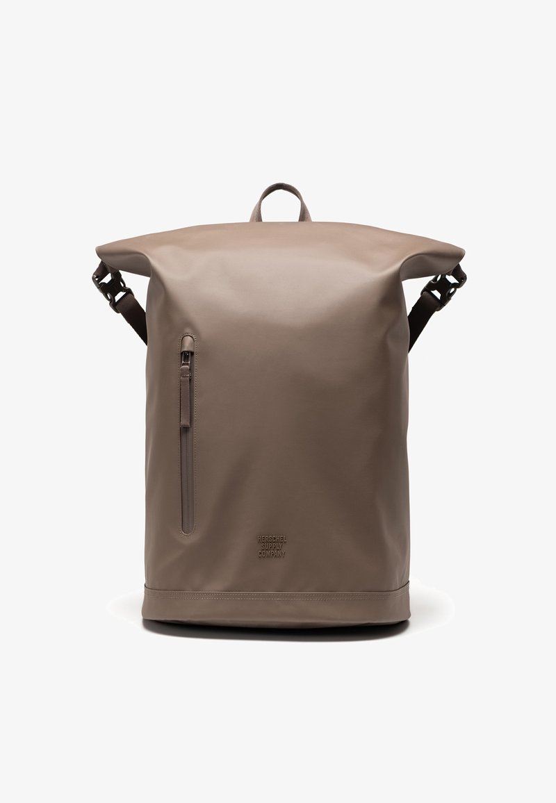 Zaino a chiusura roll-top marrone realizzato in materiale impermeabile, dotato di una tasca laterale con zip, spallacci regolabili e un logo inciso in modo discreto nella parte inferiore.