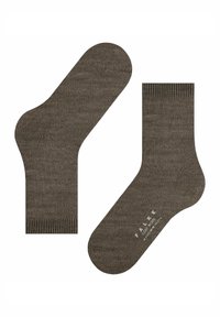 Un paio di calzini in lana marrone con polsini a coste, uno mostra la suola con il marchio in bianco "FALKE Cozy Wool."