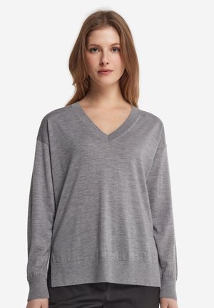 Grå v-hals sweater med lange ærmer, der har en afslappet pasform og ribbede manchetter og kant, lavet af blødt strikmateriale.