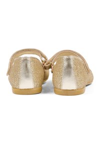 Złote brokatowe buty typu Mary Jane z metalicznym złotym akcentem na obcasie, wyposażone w pasek z tyłu zapinany na klamrę oraz płaską gumową podeszwę.