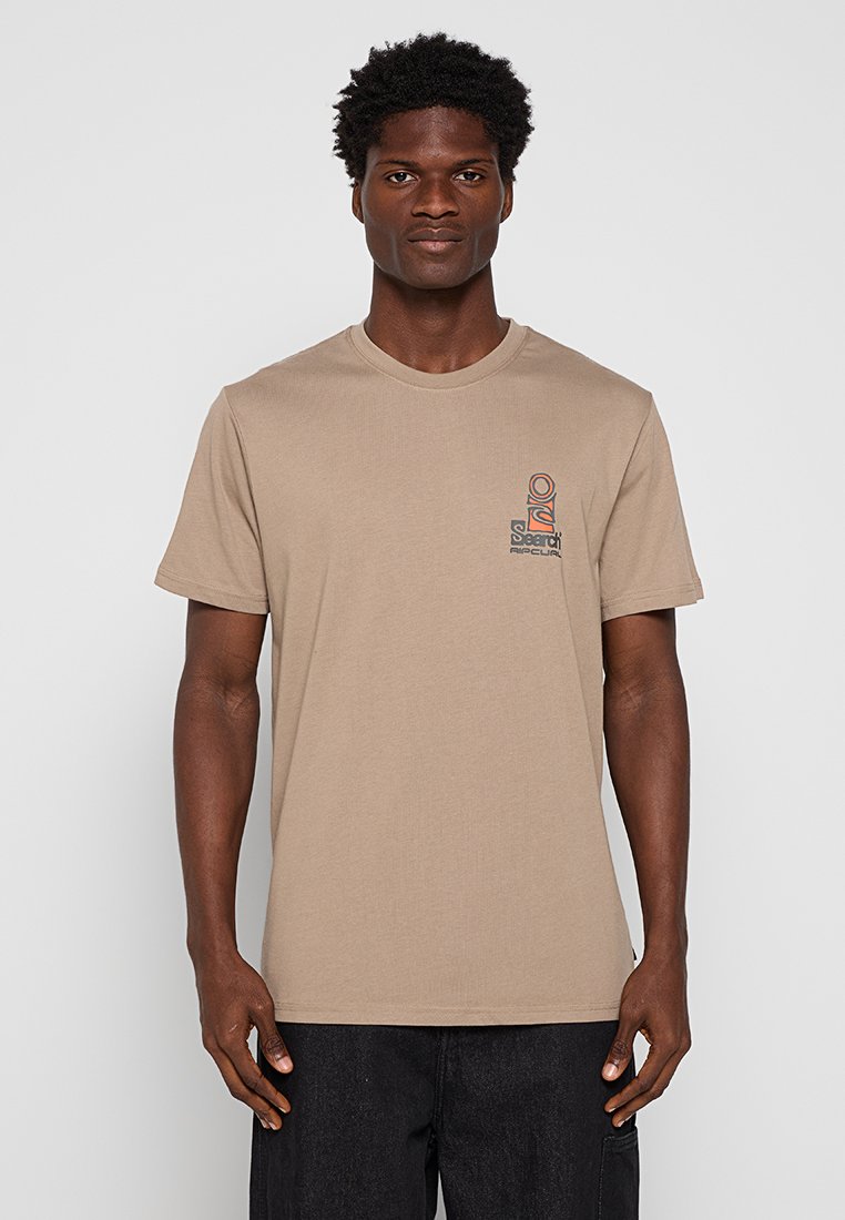 Beżowy bawełniany t-shirt z okrągłym dekoltem i krótkimi rękawami, z małą, wielokolorową grafiką na lewej stronie klatki piersiowej.