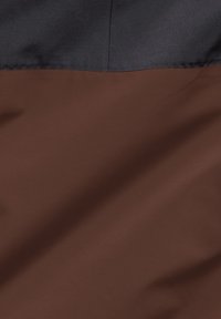 Due sezioni di tessuto: la parte superiore in satin blu navy scuro e la parte inferiore in tessuto marrone liscio, che mettono in mostra un design pulito a blocchi di colore.
