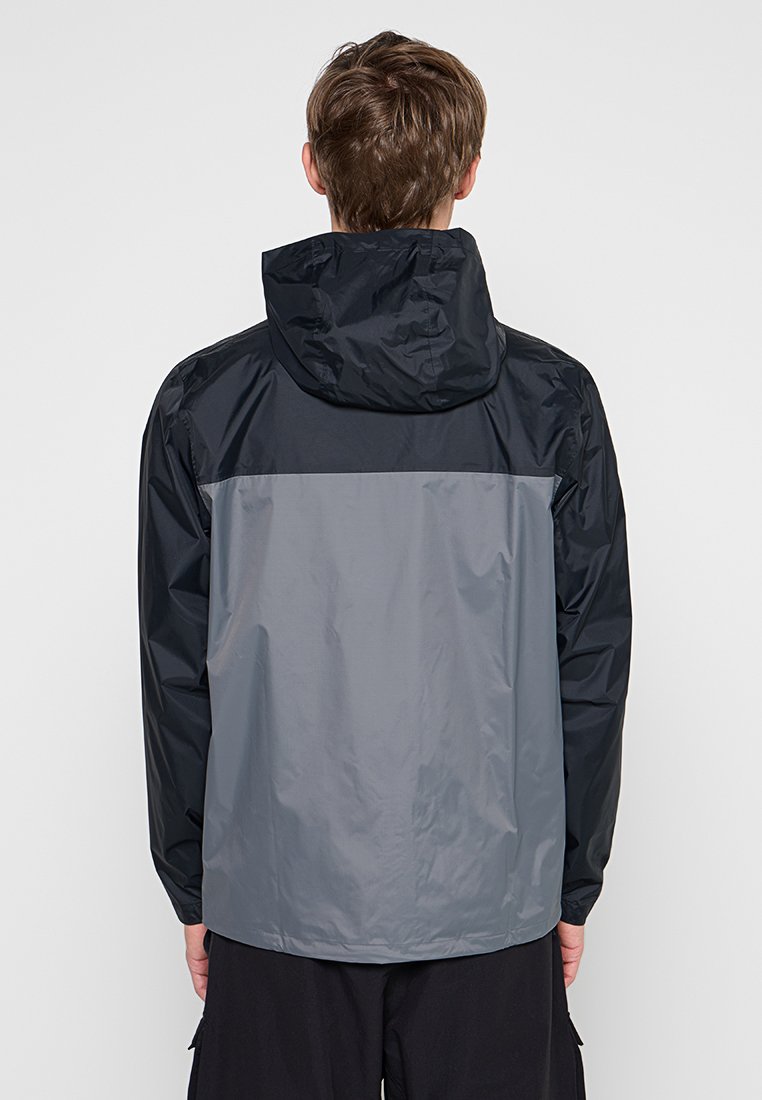 Chaqueta ligera con un tejido resistente al agua. Con un diseño a dos colores en azul marino oscuro y gris claro. Incluye capucha y puños elásticos.