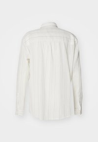 Camisa de manga larga blanca con rayas grises verticales, cuello abotonado y puños de un solo botón, que presenta un diseño de espalda plisada.