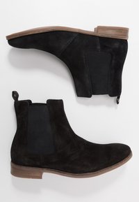 Černé semišové Chelsea boty s elastickými bočními panely a poutky, s zaoblenou špičkou a nízkým, robustním hněd�ým dřevěným podpatkem.