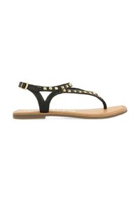 Sandalias de tiras negras con tachuelas de pirámide doradas en la correa, material de cuero y suela plana beige. Hebilla ajustable en el tobillo.