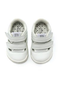 Weiße Kinderschuhe mit zwei Klettverschlüssen, glattem Lederoberteil, gepolstertem Innenraum und bedruckter Innensohle, die ein Sonnendesign zeigt.