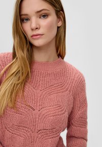 Rosa gestrickter Pullover mit einem strukturierten Wellenmuster, runder Ausschnitt und langen Ärmeln, aus einem weichen, dicken Garn gefertigt.