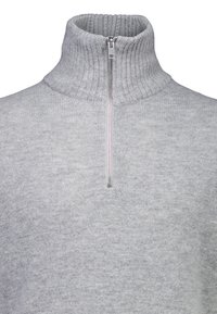 Ljusgrå polotröja, tillverkad av mjukt stickat tyg, med hög krage och halvmatchande dragkedja fram. Ribbade detaljer vid kragen och ärmsluten.